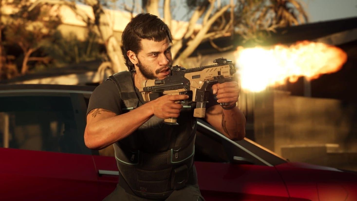 A man shots a gun overtop a car.